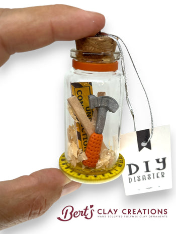 Small bottle with miniature tools and a 'DIY Disaster' tag, held by a hand.